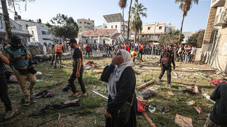 A Palestinian woman around the belongings of Palestinians cries at the garden of Al-Ahli Arabi Baptist Hospital after it was hit in Gaza City, Gaza on October 18, 2023.