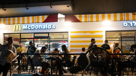 People sit at McDonald's outdoor seating after going out on a Saturday night along Rothschild Street on June 11, 2022 in Tel Aviv, Israel