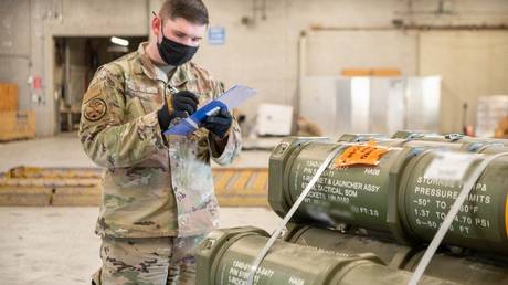 A US service member counts pallets of ammunition, weapons and other equipment bound for Ukraine at Dover Air Force Base, Delaware, on January 21, 2022.