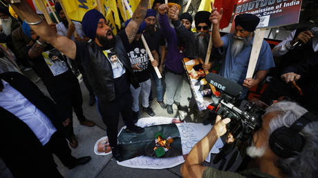 Demonstrators burn an Indian flag and deface a placard depicting Indian prime minister Narendra Modi during a Sikh rally outside the Consulate General of India, in Toronto, Ontario, Canada, on September 25, 2023