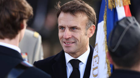 French President Emmanuel Macron greets the troops at the Arc de Triomphe in Paris on November 11, 2023.