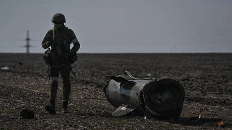 A serviceman inspects a fragment of a Tochka-U missile with cluster warhead