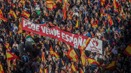 A banner saying 'PSOE sells Spain' is seen among protesters during a demonstration called by Spanish civic organizations that opposesanner the amnesty for Catalan independentists presented by the PSOE to ensure the inauguration of Pedro Sánchez as president of of the government of Spain.