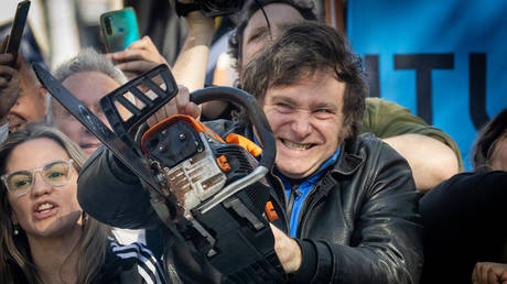 Presidential candidate Javier Milei of La Libertad Avanza lifts a chainsaw next to Buenos Aires province governor candidate Carolina Piparo of La Libertad Avanza during a rally on September 25, 2023 in San Martin, Buenos Aires, Argentina.