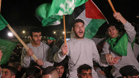 Palestinian prisoners cheer after being released in exchange for hostages freed by Hamas in Gaza, on November 24, 2023