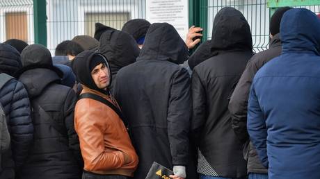 Labor migrants are pictured in front of the Migrant center in Russia's Kaluga region.