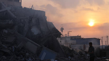 A Palestinian man stands in front of the ruins of a building destroyed in Israeli airstrikes in Gaza City on October 8, 2023