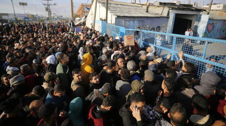 Palestinians line up for flour distributed by the UN refugee agency on Thursday in Deir Al Balah, Gaza.