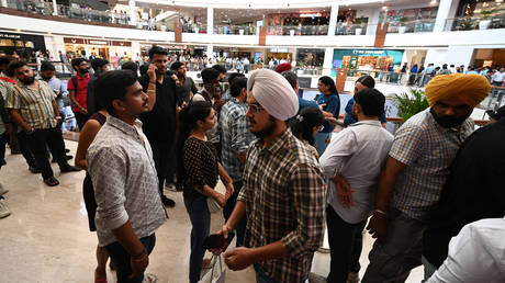 Shoppers stand in queue to buy Apple iPhones Series 15 at a mall in New Delhi in September 2023.