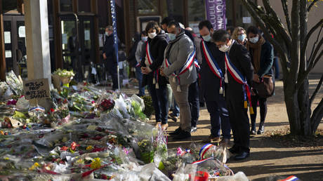 FILE PHOTO: People place flowers in front of the middle school where school teacher Samuel Paty was murdered, October 18, 2020, Conflans-Sainte-Honorine, France.