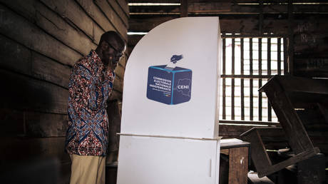 A voter marks his ballot in a voting booth at a polling station at the Institut Ndahura in Goma on December 21, 2023.