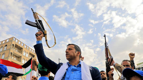 Yemenis brandish rifles and wave Palestinian flags during a march in solidarity with the people of Gaza on November 10, 2023, in the Houthi-controlled capital Sanaa.