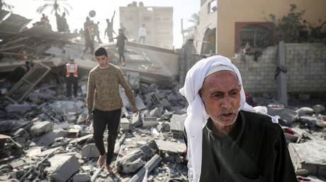 Palestinians look through the rubble of a home destroyed by an Israeli bombing on Friday in the central Gaza Strip.