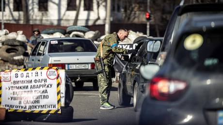 FILE PHOTO. A member of the Ukrainian Territorial Defense Forces checks cars at a checkpoint in Kyiv.