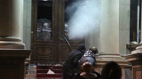 Protesters throw stones at police who use tear gas at the Belgrade City Council in Serbia on December 24, 2023.