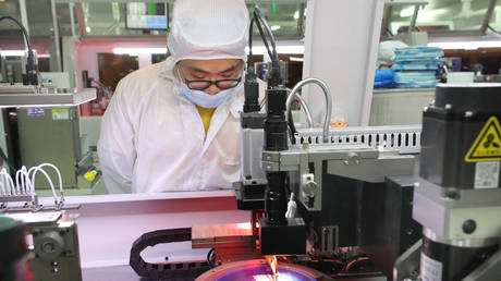 An employee makes chips at a factory of Jiejie Semiconductor Company in Nantong, in eastern China's Jiangsu province on March 17, 2021