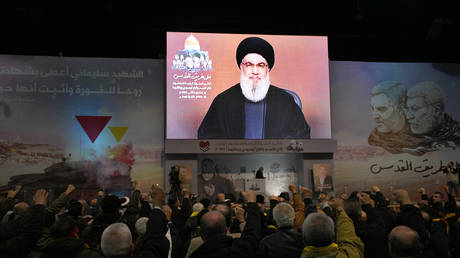 Supporters raise their fists and cheer as they listen to a speech by Hezbollah leader Sayyed Hassan Nasrallah in Beirut, Lebanon, January 3, 2024