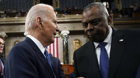 FILE PHOTO: US President Joe Biden talks with Defense Secretary Lloyd Austin.