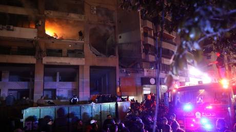 Firefighters and civil defense are seen in a damaged building targeted by an Israeli drone strike in Beirut, Lebanon on January 2, 2024.