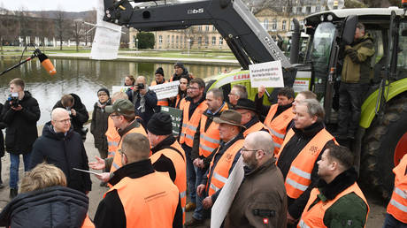 Michael Theurer (FDP), (L) State Secretary of the Federal Ministry for Digital Affairs and Transport, talks to protesting farmers at the Opera House in Stuttgart, southern Germany on January 6, 2024