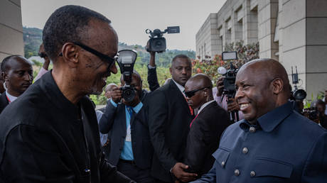 Rwandan President Paul Kagame (L) is greeted by Burundi's President Evariste Ndayishimiye (R).