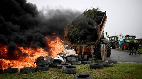 Farmers set branches and tires on fire as they demonstrate in Sainte-Colombe-en-Bruilhois near Agen, France, January 25, 2024.