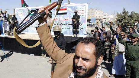 A man rises a rifler as people gather to stage a protest against United Nations (UN) Security Council resolution demands that Houthis immediately cease all attacks on ships in Red Sea in Sanaa, Yemen on January 11, 2024