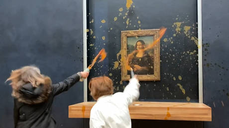 This image grab taken from AFPTV footage shows two environmental activists from the collective dubbed "Riposte Alimentaire" (Food Retaliation) hurling soup at Leonardo Da Vinci's "Mona Lisa" (La Joconde) painting, at the Louvre museum in Paris, on January 28, 2024.