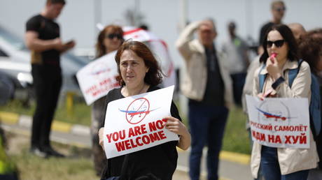 People protest as a Russian passenger plane lands in Tbilisi, Georgia on May 19, 2023.