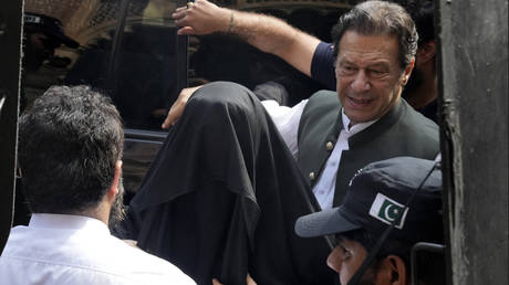 FILE PHOTO: Pakistan's former Prime Minister Imran Khan (R) with his wife Bushra Bibi (C) arrive to appear in a court in Lahore, Pakistan, on June 26, 2023