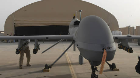 US contractors load Hellfire missiles onto an MQ-1C Gray Eagle drone at Camp Taji, Iraq, February 27, 2011
