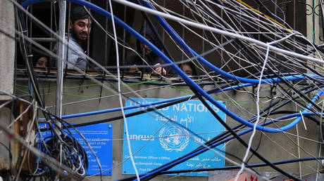 FILE PHOTO: Palestinians look out through improvised electricity cables and water tubes at the Bourj al-Barajneh refugee camp near Beirut, Lebanon, February 5, 2024.