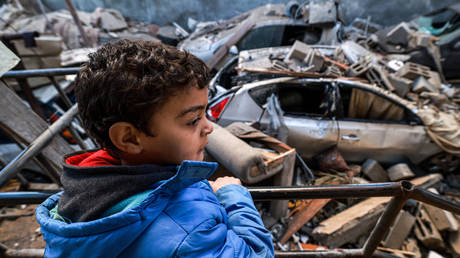 A child looks on while standing by rubble in the aftermath of Israeli bombardment on Rafah in the southern Gaza Strip on February 7, 2024.