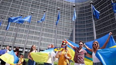 Demonstrators wave Ukrainian flags in front of the headquarters of the European Commission in Brussels.