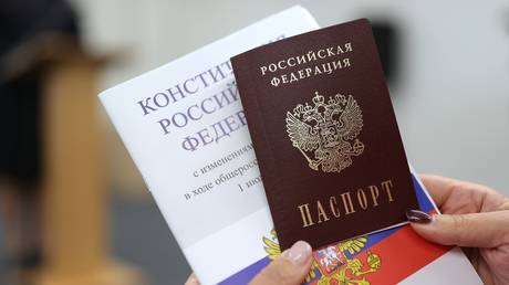 FILE PHOTO: A woman shows off her newly-acquired Russian passport.