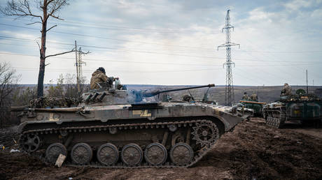 FILE PHOTO: Ukrainian servicemen ride their tank at a firing range.