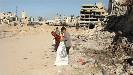 Palestinian children collect supplies near destroyed buildings in Gaza City on March 5, 2024.
