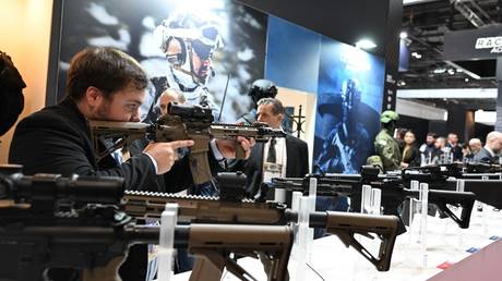 A man inspects a carbine rifle by Colt during a security expo in Villepinte, Paris, November 14, 2023