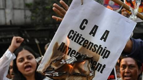 Activists shout slogans as they burn a copy of the Citizenship Amendment Act (CAA) bill during a protest rally in Kolkata on March 12, 2024.