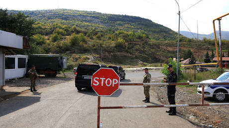FILE PHOTO: Vehicles pass a checkpoint as they drive towards the city of Stepanakert.