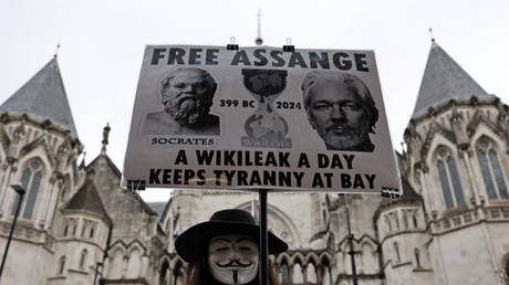 A demonstrator holds a placard in support of Julian Assange outside the Royal Courts of Justice in London, Britain, February 21, 2024