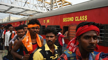 Passengers queue along a platform to board the Chennai-bound Coromandel Express at Shalimar station near Kolkata on June 7, 2023.