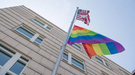 File photo: A rainbow flag hangs under a US flag at the US embassy in Berlin, Germany, 25 July 2019.