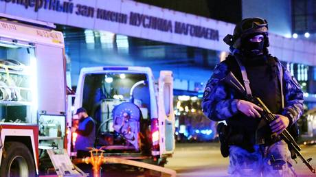 A Russian law enforcement officer stands guard outside the Crocus City Hall concert venue following a mass shooting.