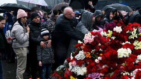 People mourn at a makeshift memorial in memory of the victims of the March 22 terrorist attack on the Crocus City Hall concert venue near Moscow, in Moscow Region, Russia.