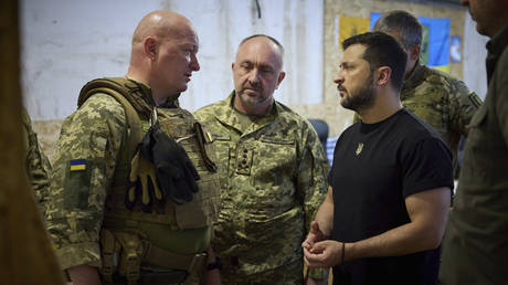 FILE PHOTO: Ukrainian General Aleksandr Pavlyuk (C) stands as President Vladimir Zelensky (R) takes a report from a senior marines commander.