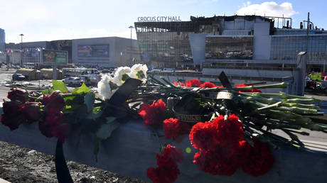 Flowers are seen left by the burnt-out Crocus City Hall concert venue in Krasnogorsk, outside Moscow, on March 25, 2024.