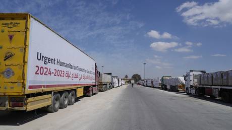 Humanitarian aids trucks line up to cross the Rafah border crossing between Egypt and the Gaza Strip, March 23, 2024