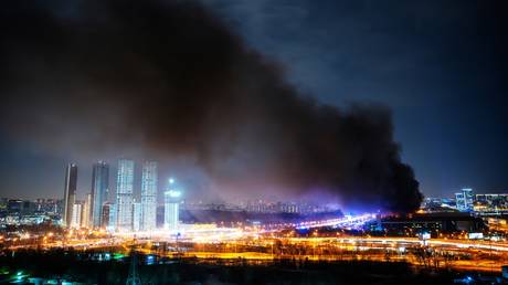 Smoke from fire rises above the burning Crocus City Hall concert venue following a shooting incident, outside Moscow, Russia.