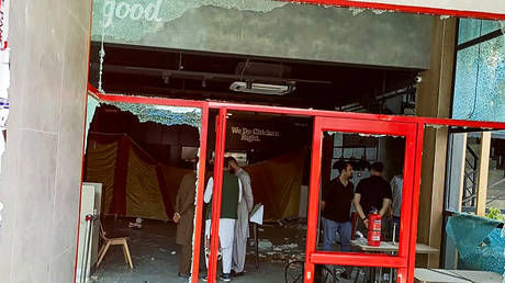 Security personnel inspect the damaged KFC restaurant, set on fire by pro-Palestinian protesters in the northeastern town of Mirpur, Pakistan-administered region of Kashmir on March 30, 2024. © AFP